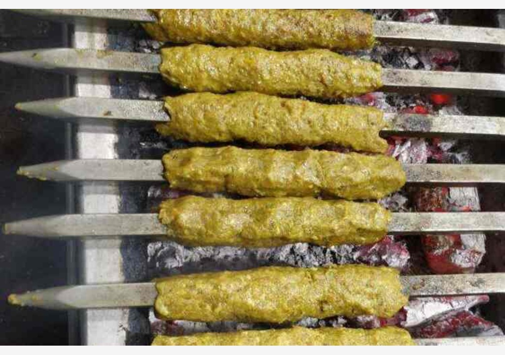 Baking seekh kabab with skewers on coal